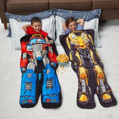 two children laying on the floor next to pillows