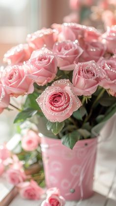 a pink vase filled with lots of pink roses