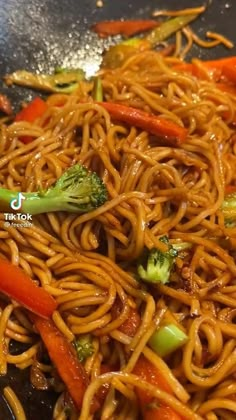 stir fry noodles with broccoli and carrots in a wok