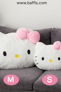 two hello kitty pillows sitting on top of a couch with the letters m and s