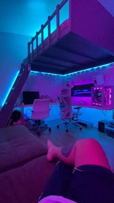 a person laying on the floor in front of a bunk bed with purple lighting underneath