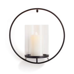 a candle is sitting in the middle of a circular holder with an iron ring around it