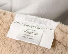 a label on the back of a white jacket that says evergreen written in american phosphern