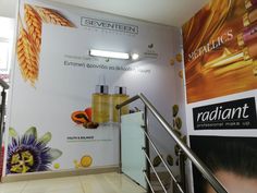 the wall is decorated with advertisements for cosmetics and beauty products, including an espresso machine