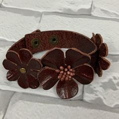 a brown leather bracelet with flowers on it