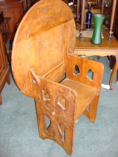 an old wooden bed frame sitting on top of a blue carpeted floor next to a table