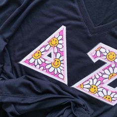 an embroidered t - shirt with flowers and smiley faces on it