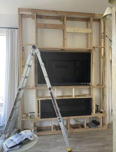 two ladders are in front of a television being built