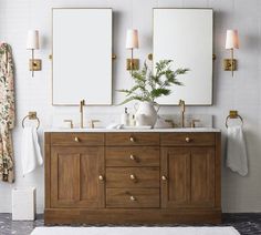 a bathroom vanity with two mirrors above it