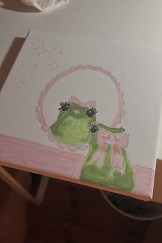 a painting of a frog with a pink bow on it's head and eyes