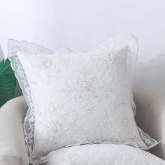 two white pillows sitting on top of a chair