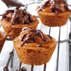 several cupcakes with chocolate and caramel toppings on a wire cooling rack