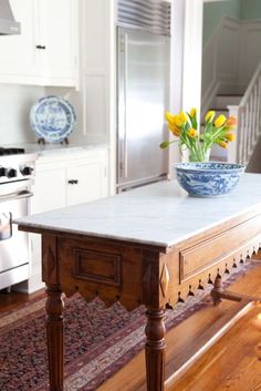 a blue and white bowl sitting on top of a wooden table next to a stove