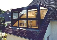 an open window on the side of a building with a view of a kitchen and dining area