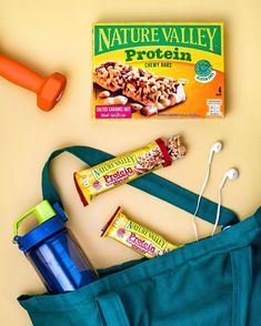 the contents of a gym bag laid out on top of a yellow table with a blue tote bag