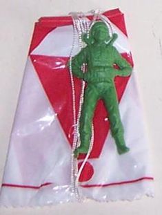 a green soldier ornament hanging from a red and white bag