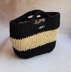 a crocheted black and white purse on a table