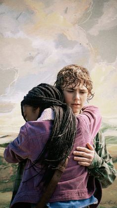 two children hugging each other in front of a painting