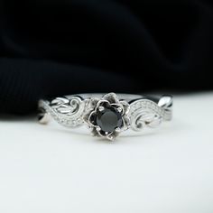 a black diamond ring sitting on top of a white surface