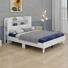 a white bed sitting in a bedroom on top of a hard wood floor