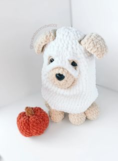 a stuffed animal with a knitted face next to an apple