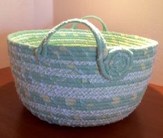 a green and white basket sitting on top of a wooden table