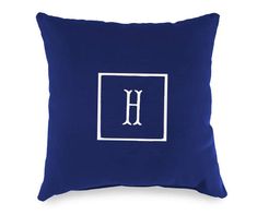 a blue pillow with the letter h in white on it's front and back