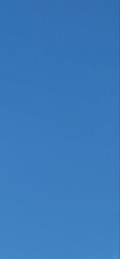 an airplane is flying high in the sky on a clear day with blue skies behind it