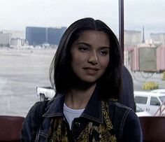 a woman standing in front of a window looking at the camera