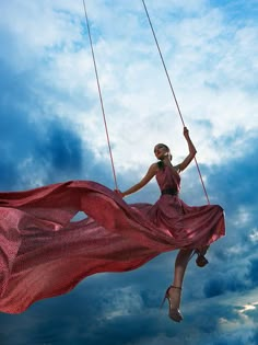 a woman flying through the air on top of a red kite with words above it