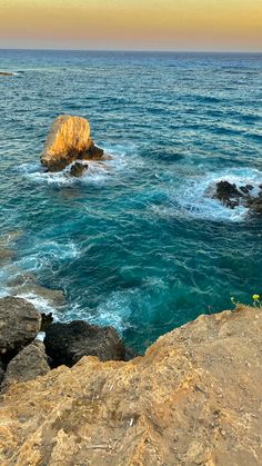 an ocean view with rocks and blue water