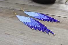 These gorgeous blue and gold beaded earrings are made with high quality Japanese glass seed beads, and gold tone ear wire hooks in 3 different shades of blue. Other finishes are also available.  5 1/2" inches in length from ear hook to last bead 1  " wide *All orders are shipped within 3-7 business days (after the order has been placed) by first class mail with a tracking information. If you need sooner please let me know. All custom orders will be shipped within 1-2 weeks.  *All pieces are handmade and each piece is unique and should be handled with care. Please be kind to your jewelry. Apply any lotions or perfumes before putting on your jewelry and store in a cool dry place. *Sending a gift? Leave me a note at checkout and I can add a personalized message from you to the recipient free Elegant Blue Beaded Earrings With Tiny Beads, Blue Teardrop Earrings With Tiny Beads, Blue Drop Earrings With Tiny Beads, Adjustable Blue Beaded Chandelier Earrings, Bohemian Blue Long Drop Beaded Earrings, Blue Dangle Earrings With Tiny Beads, Blue Beaded Fringe Drop Earrings, Blue Beaded Fringe Dangle Earrings, Blue Hand-strung Dangle Beaded Earrings