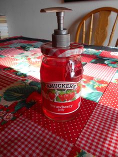 a hand soap dispenser sitting on top of a red checkered table cloth