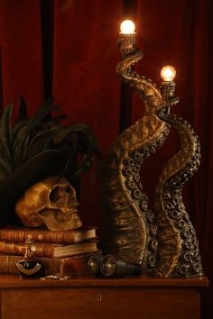 a skull with a hat on top of it next to some books and a candle