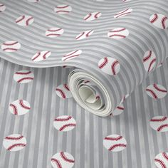 a baseball themed wallpaper with red and white balls on grey striped paper, which is rolled up to the side