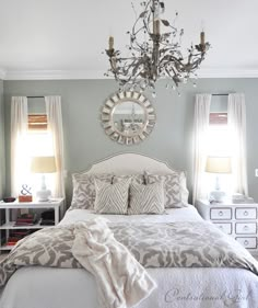 a bedroom with a chandelier hanging from the ceiling and a bed in front of it