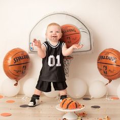 a little boy standing in front of some basketballs