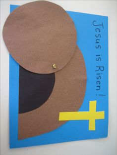 a cross is placed on the side of a paper piece with scissors and tape around it