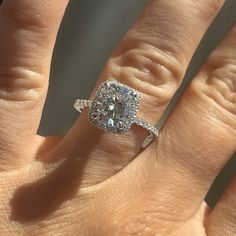 a woman's hand with a ring on it and a diamond in the middle