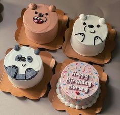 four decorated birthday cakes sitting on top of cardboard trays in the shape of animals