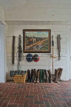 there is a painting hanging on the wall next to some boots and other things in front of it