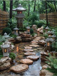 a small garden with rocks and lights in the water, surrounded by trees and plants