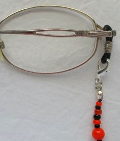 You'll always keep your reading glasses nearby using this mixed orange & black beaded eyeglass chain! 27" in length, made with glass beads, beading cord, metal lobster clasps, and adjustable rubber holders. Lobster clasps make it easy to change the rubber holders, and an extra pair of holders included with every purchase. This mixed orange & black beaded eyeglass chain will arrive in a gift box, ready to give as a present or to keep and store. Back to Beaded Eyeglass Chains Beaded Eyeglass Chain, Beading Cord, Chain Lanyard, Eyeglass Chain, Eyewear Accessories, Black Rubber, Reading Glasses, Black Glass, Black Beads