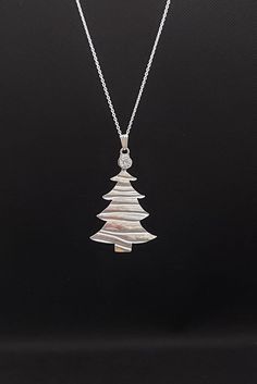 Fun yet stylish Christmas tree pendant.  As with every proper Christmas tree this little silver tree is topped with a special sparkly gem  - of  cubic zirconia.  Artisan crafted with a unique texture highlighting the branches of the "tree".  Comes complete with a sterling silver chain.  Presented in an attractive Christmas gift box this makes the perfect present for the festive season. Special order with 24inch chain Christmas Silver Cubic Zirconia Necklace, Silver Cubic Zirconia Necklaces For Christmas, Holiday Sterling Silver Necklaces, Holiday Sterling Silver Necklaces In Silver, Silver Christmas Pendant Necklace, Silver Christmas Tree, Silver Tree, Art Pendant, Mothers Necklace