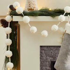 a fireplace decorated for christmas with stockings and pom - poms