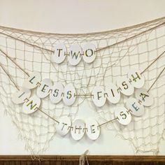 there is a string net with words on it and some strings hanging from the wall