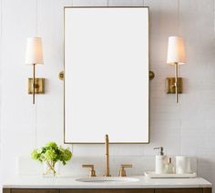 a bathroom vanity with two sinks and a large mirror above it, along with gold faucets