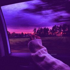 a person's hand on the dashboard of a car as the sun goes down