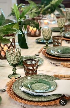 the table is set with green dishes and place settings