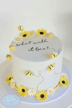 a white cake with yellow flowers and bees on the top is decorated with words that read, what will it bee?